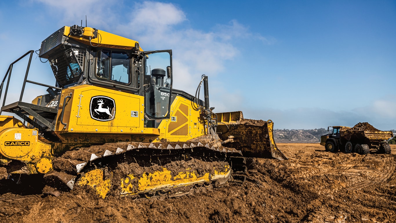 850L Dozer on a worksite with a dumptruck in the background.